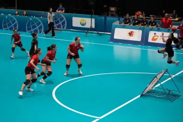 A Singaporean striker is stretching out above the frame, ready to shoot. Three Swiss defenders are positioned around the forbidden zone.